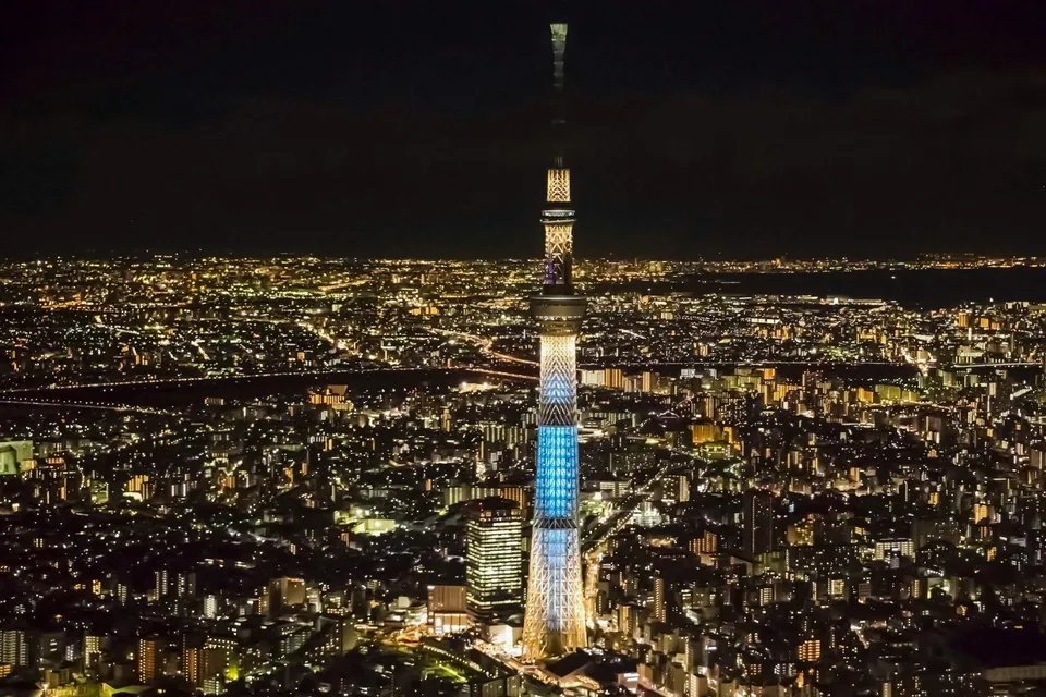 Tokyo Skytree illuminated at night, towering over the cityscape.
