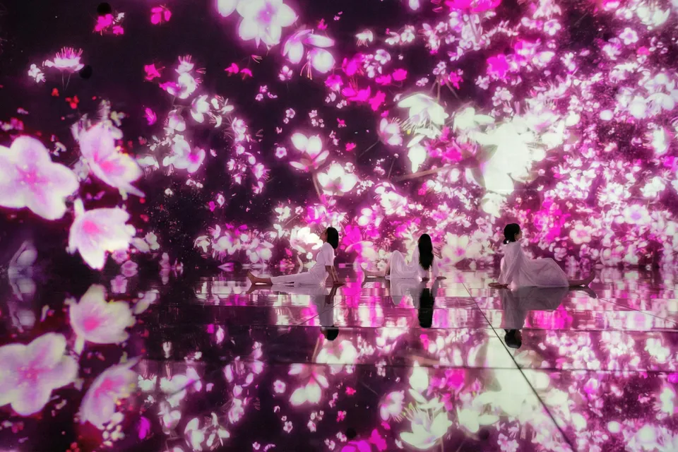 Visitors in immersive floral digital art at teamLab Planets Tokyo.
