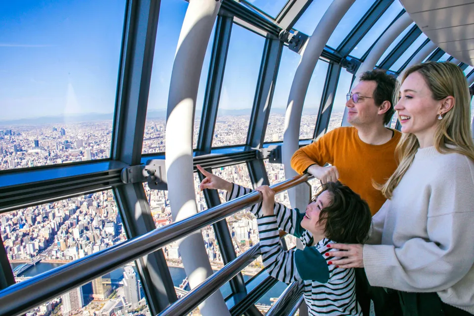 Family enjoying panoramic view from Tokyo Skytree observation deck.