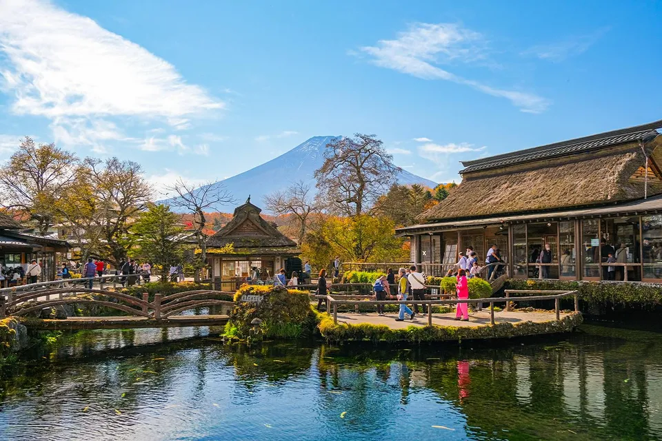Visitors at Oshino Hakkai ponds with Mount Fuji in the background, Japan.