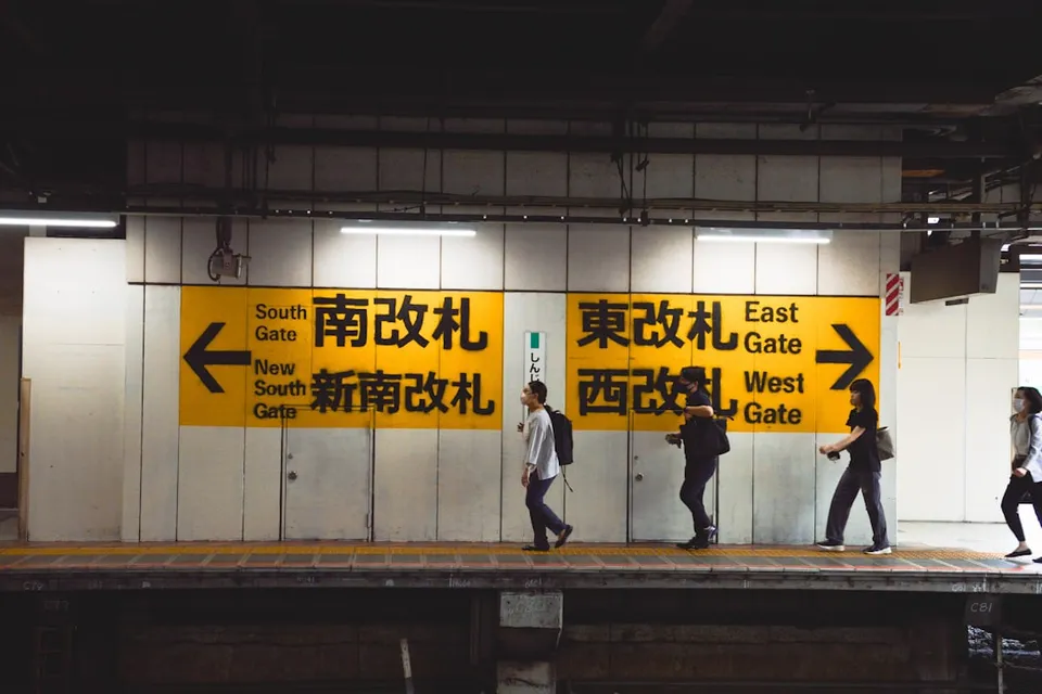 A group of people walking across a train platform