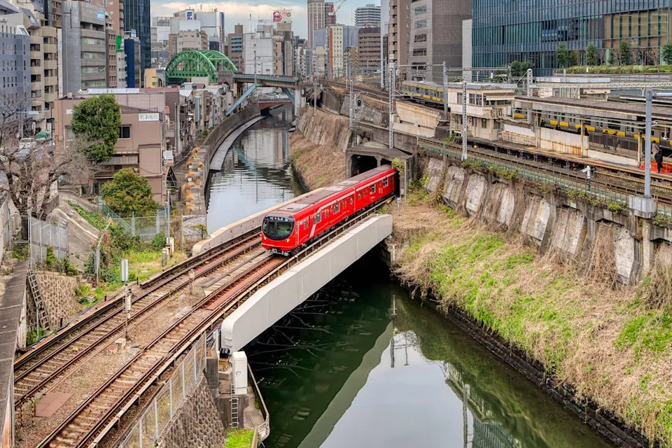 a red train traveling over a bridge over a river
