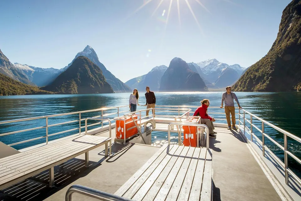 Cruise passengers enjoying Milford Sound views with mountains and clear water.