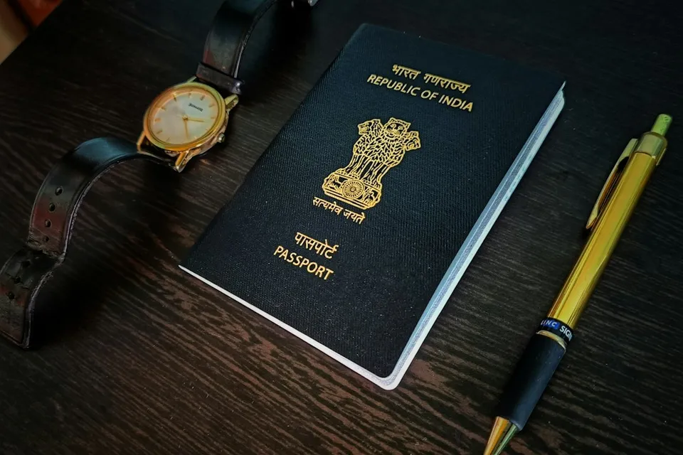 a passport, watch and pen on a table