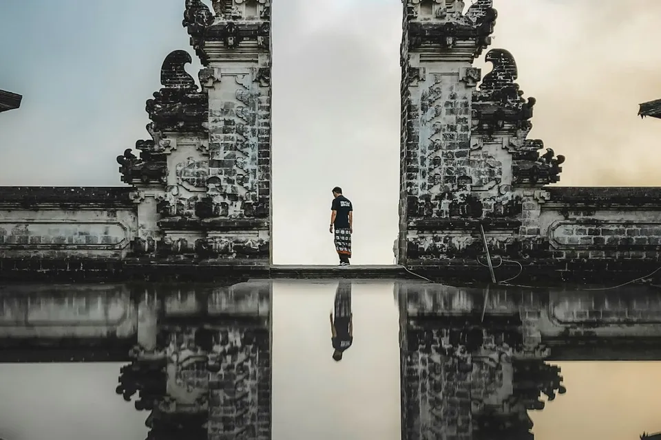 A person standing between the split stone gates of Lempuyang Temple in Bali