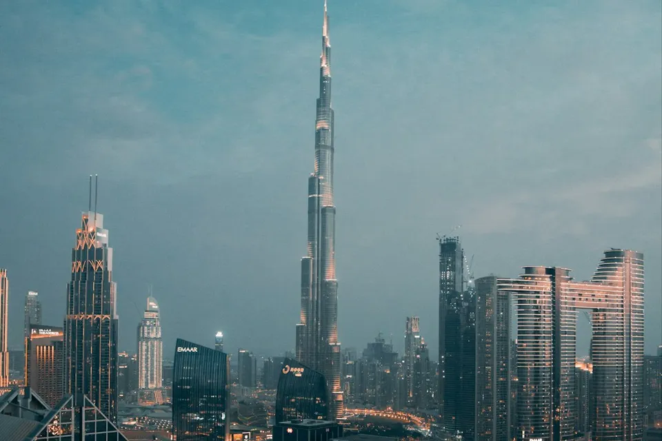 The Burj Khalifa tower rising above the illuminated skyline and highway interchange in Dubai