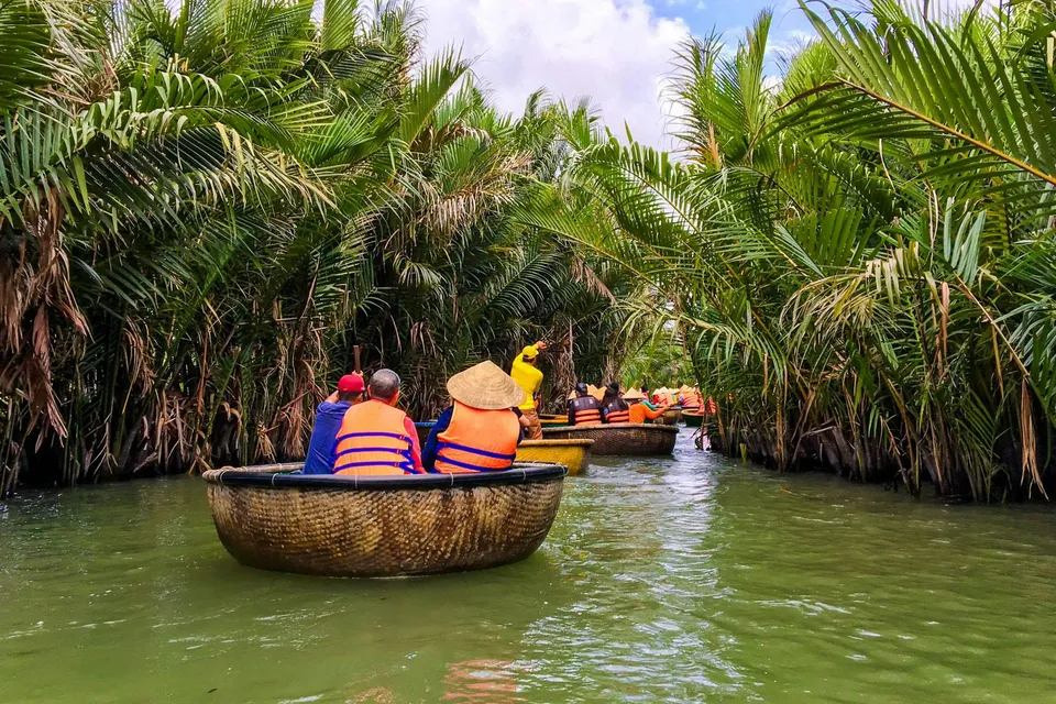Tourists navigating a river in bamboo basket boats, Hoi An, Vietnam.