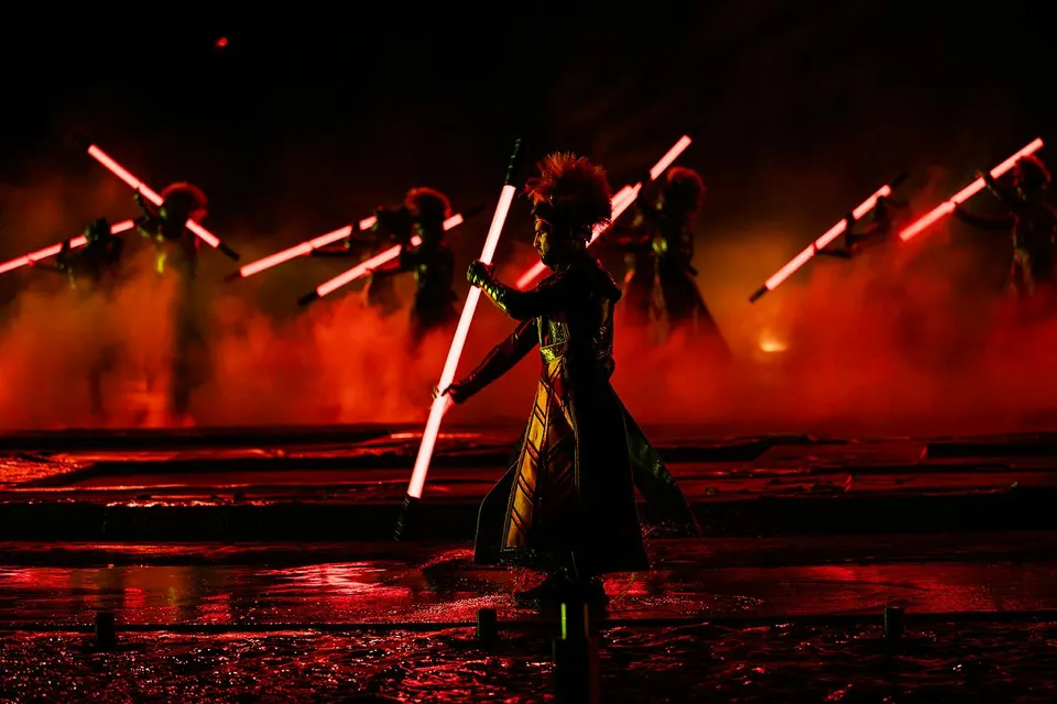 Performers with glowing red staffs in the Kiss of the Sea Show.