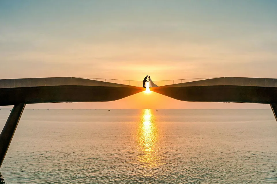 Couple on Kiss Bridge at sunset, Phu Quoc Island, Vietnam.