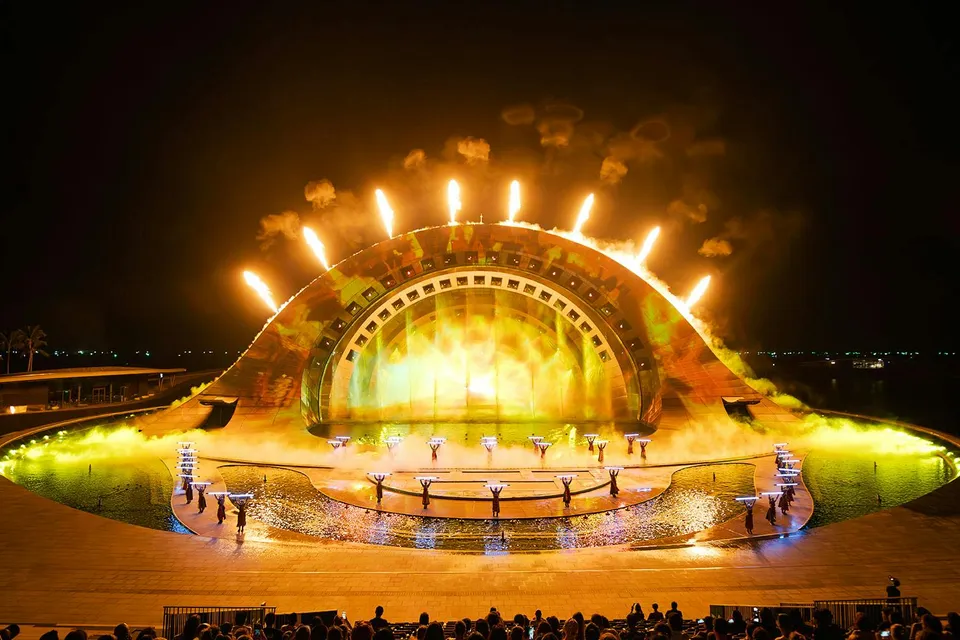 Performers with fire effects at Kiss of the Sea Show, vibrant stage lighting.