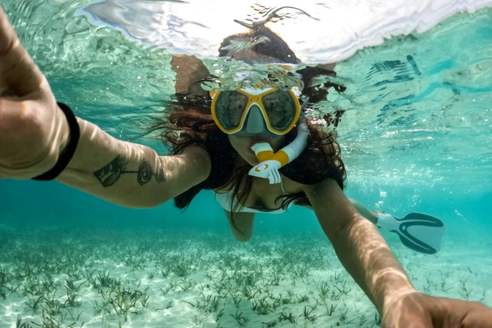 Woman snorkeling in the clear, blue ocean