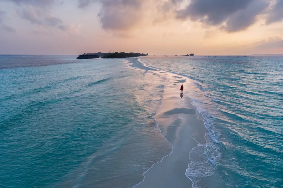 a person walking along a beach next to the ocean