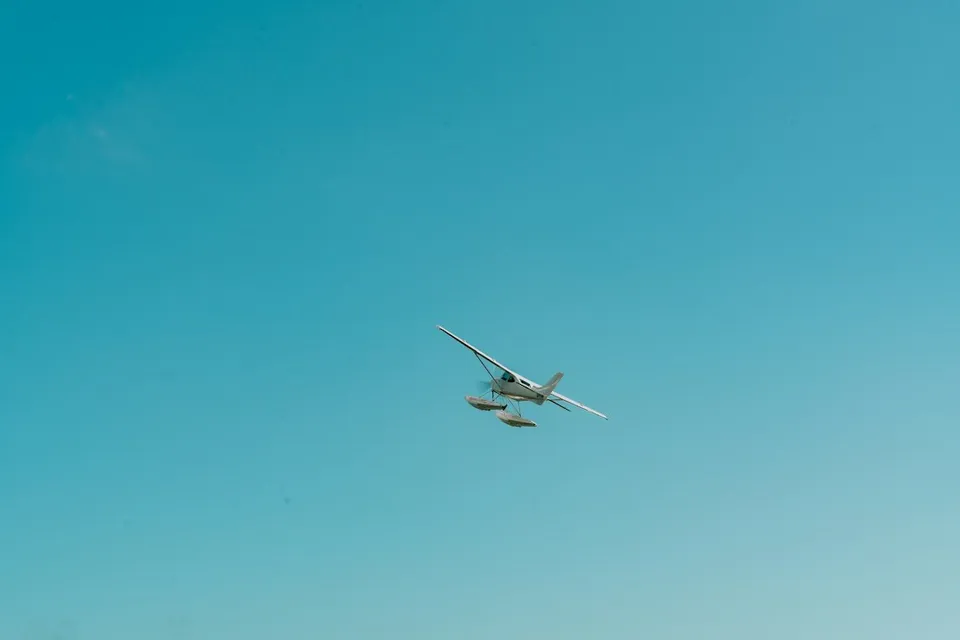 A plane flying in the sky over a beach