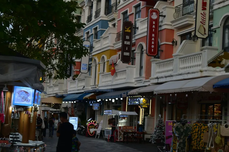 Colorful buildings line a street with shops and awnings