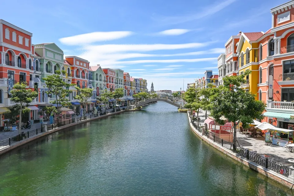 Colorful buildings line a canal with a bridge