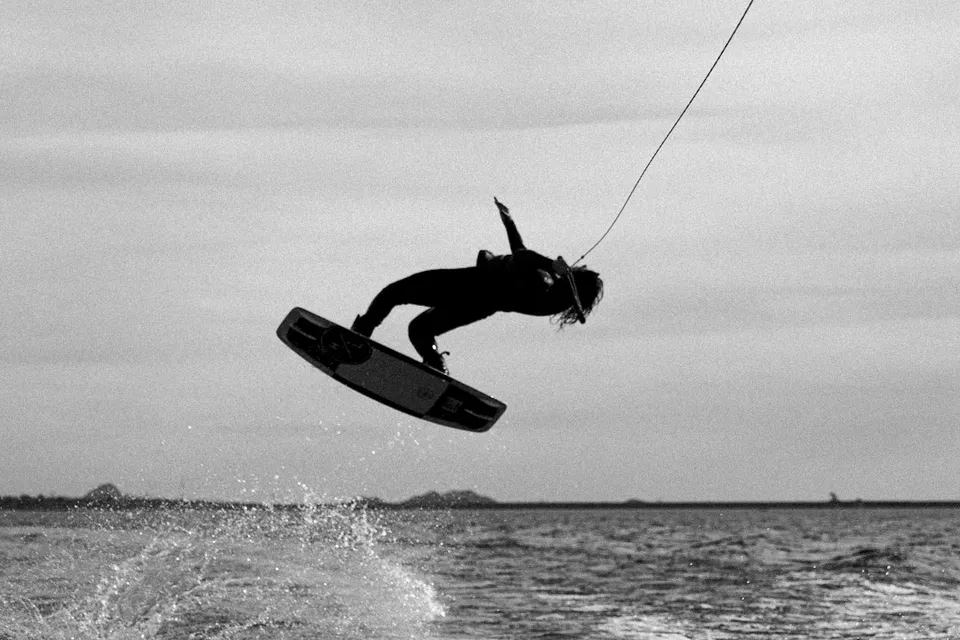 a person on a surfboard in the air above the water