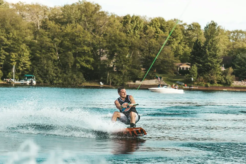 man in red shorts riding red kayak on water during daytime