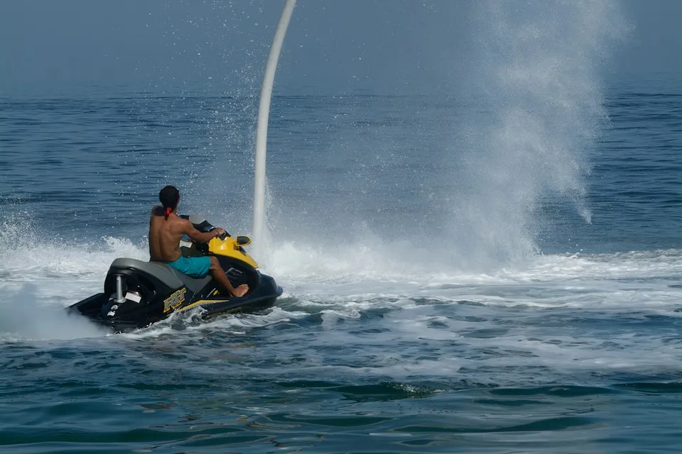 A man riding a jet ski while being pulled by a boat