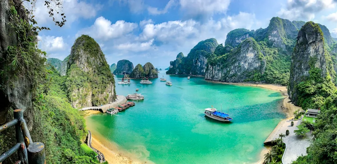 Boats on the turquoise water of Ha Long Bay surrounded by limestone karst islands