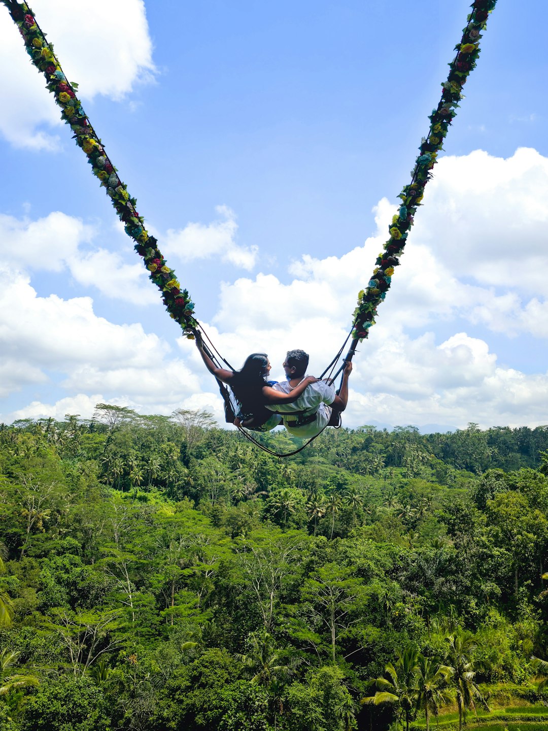 a man riding a hammock in the middle of a forest