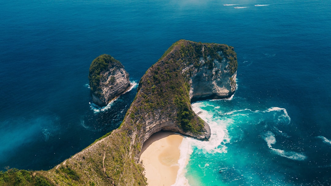 brown and green rock formation on blue sea water during daytime