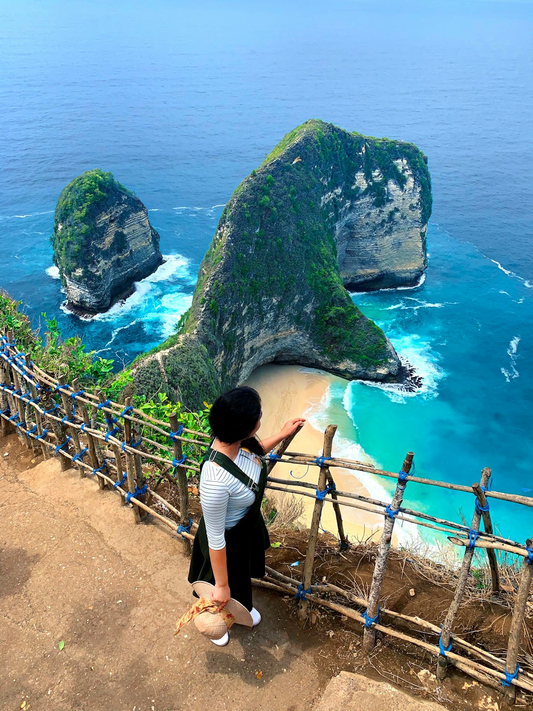 woman in black tank top and black pants standing on brown wooden bridge during daytime