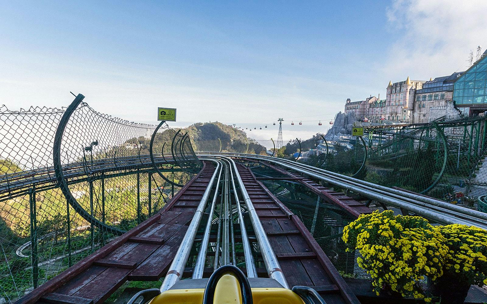 Alpine Coaster track view at Ba Na Hills with cable cars and mountain scenery.
