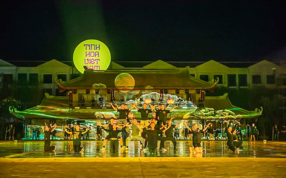 Performers on stage at The Quintessence of Vietnam Show, Hanoi, with traditional backdrop.
