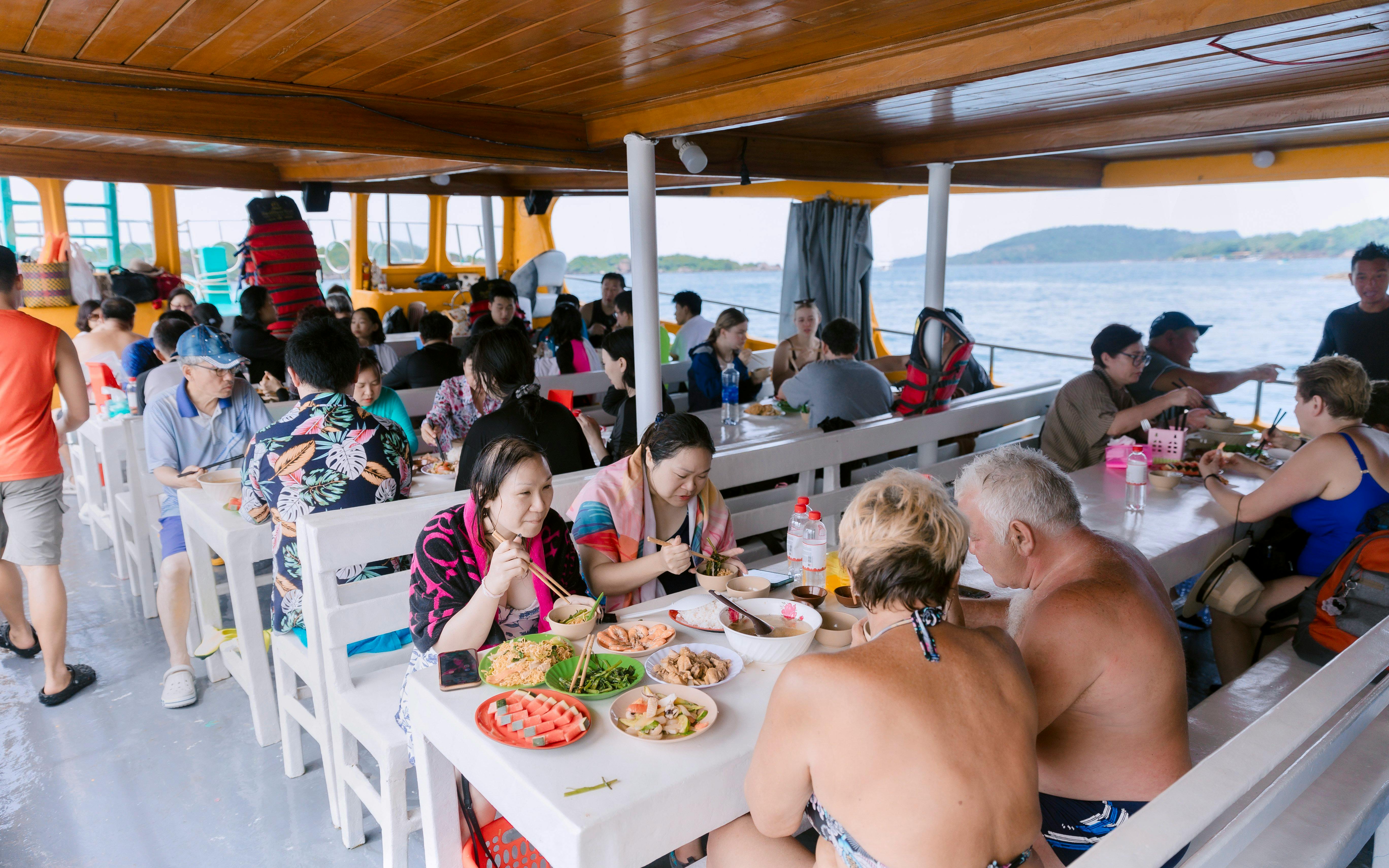 Tourists enjoying lunch on a boat during the 3 Island Hopping Tour in Phu Quoc.