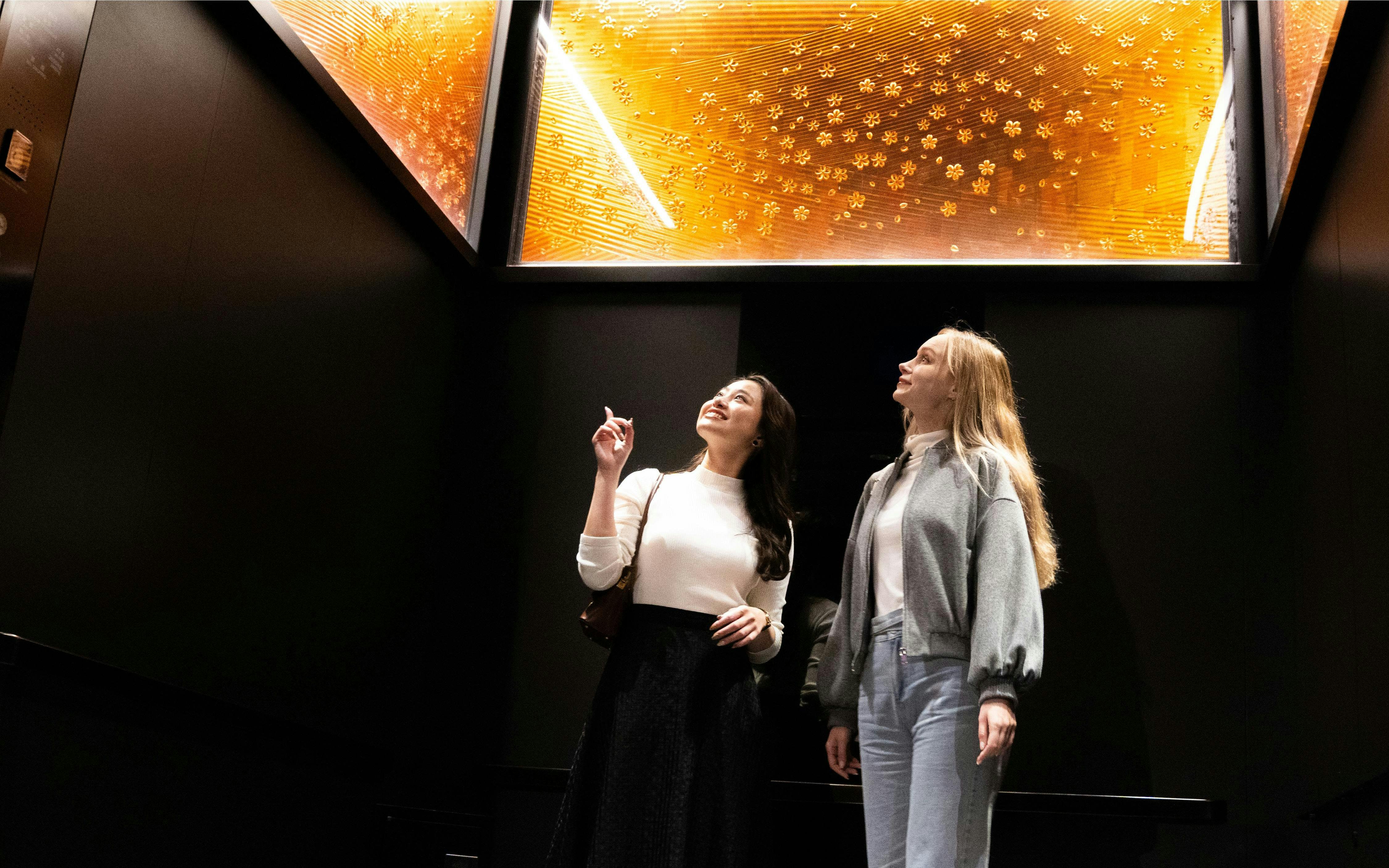 Visitors admiring illuminated art installation inside Tokyo Skytree.