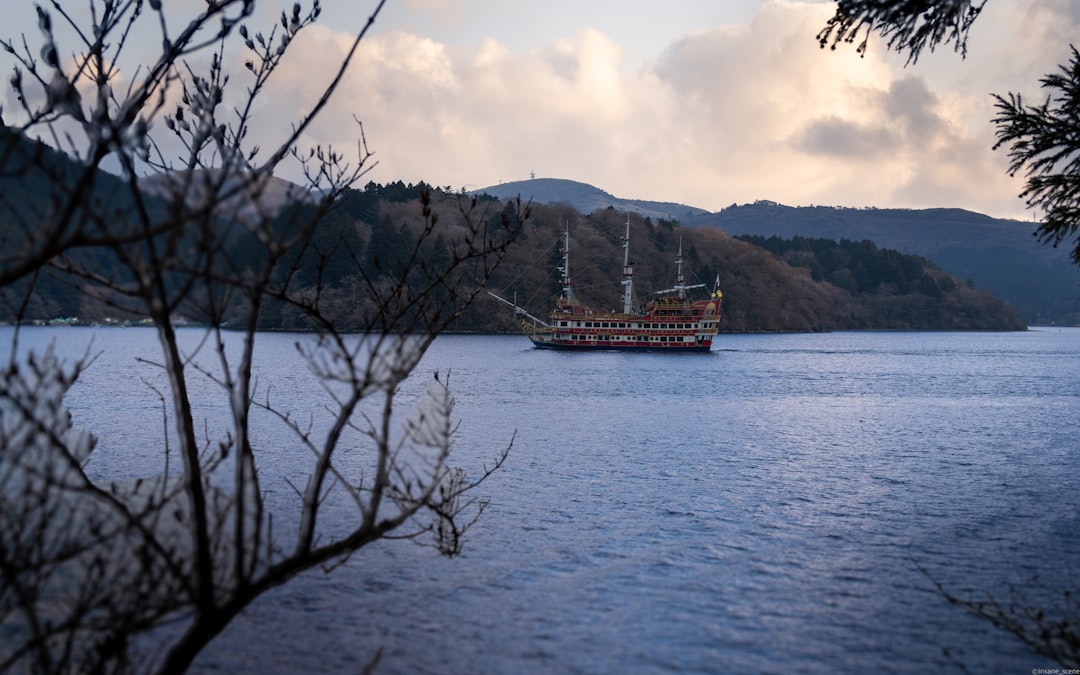 A large ship sails on a calm lake near mountains.
