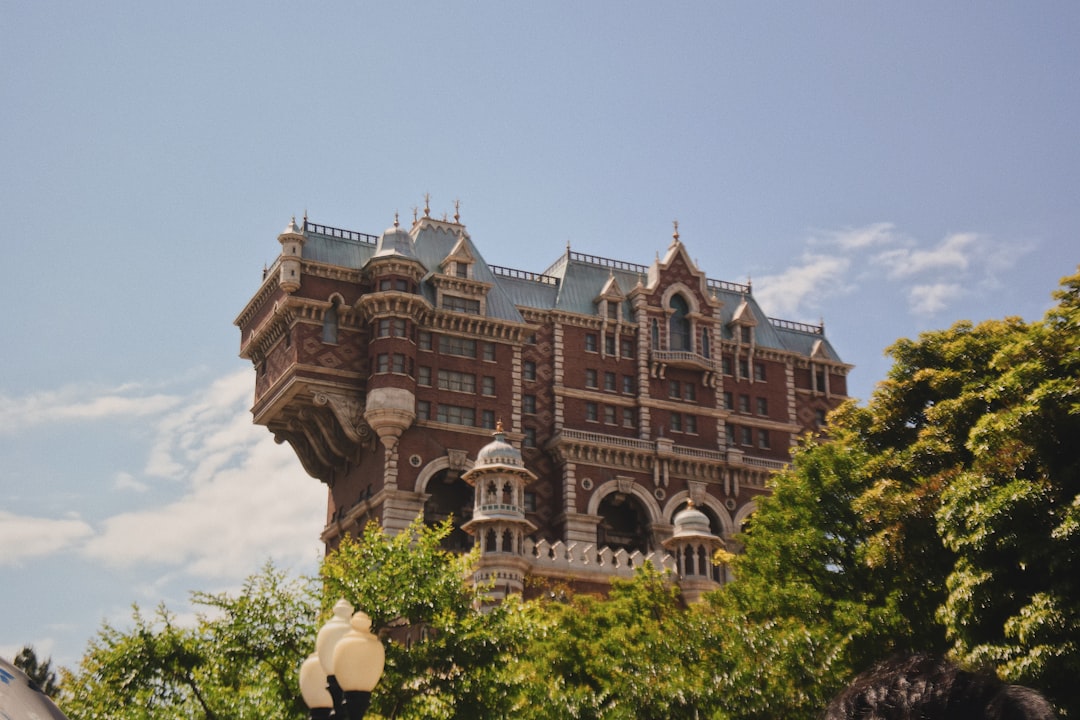 brown building near green trees under blue sky