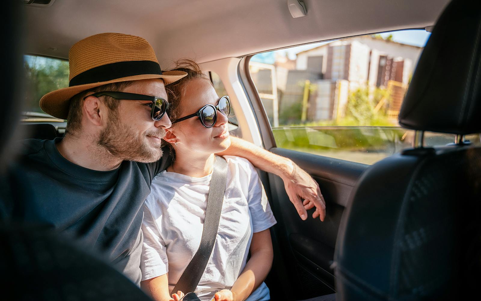 Couple enjoying a car transfer, seated in the backseat.