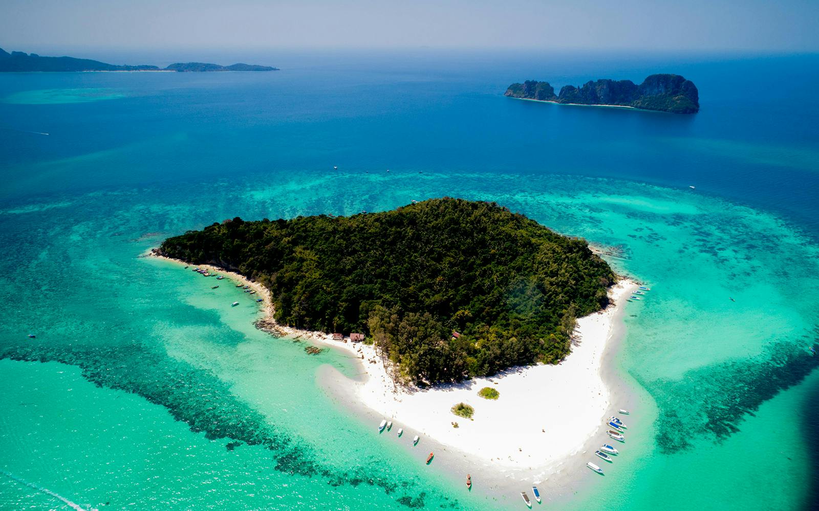 Aerial view of Bamboo Island's lush greenery and white sandy beaches in Thailand.