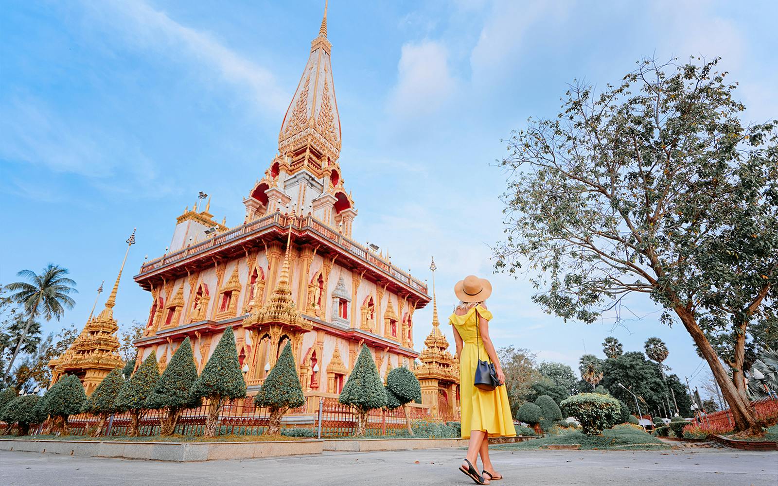 Woman in yellow dress visiting Wat Chalong temple in Phuket on a guided tour.