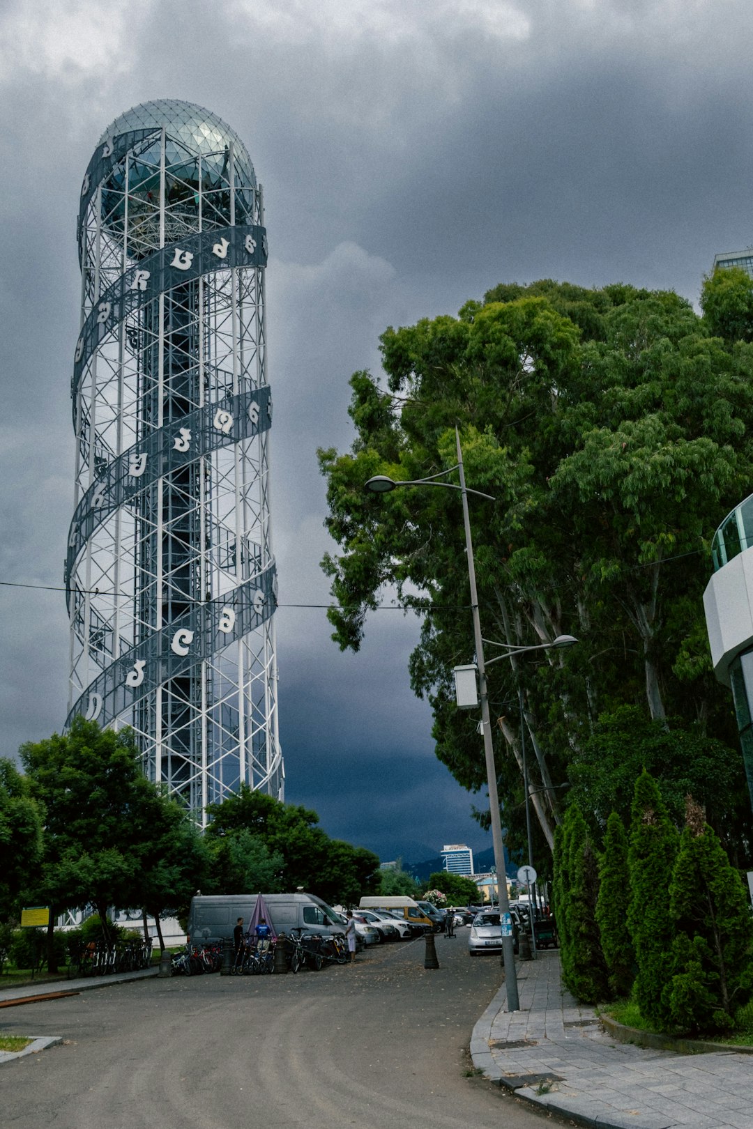 A unique spiral tower rises under a dark, cloudy sky