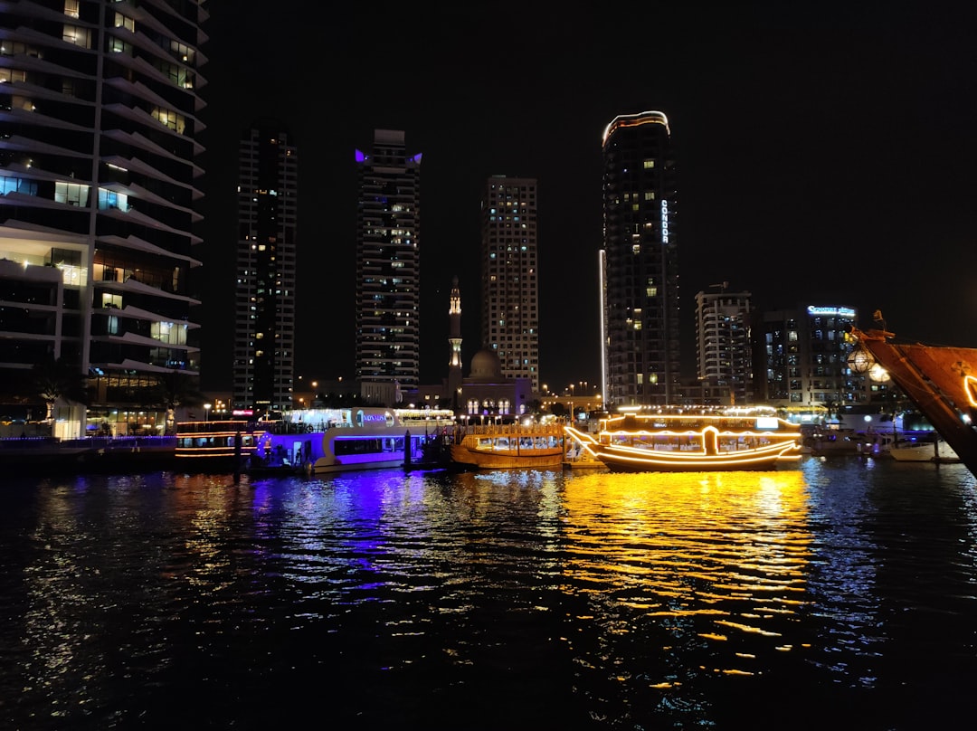City skyline with illuminated boats on the water at night