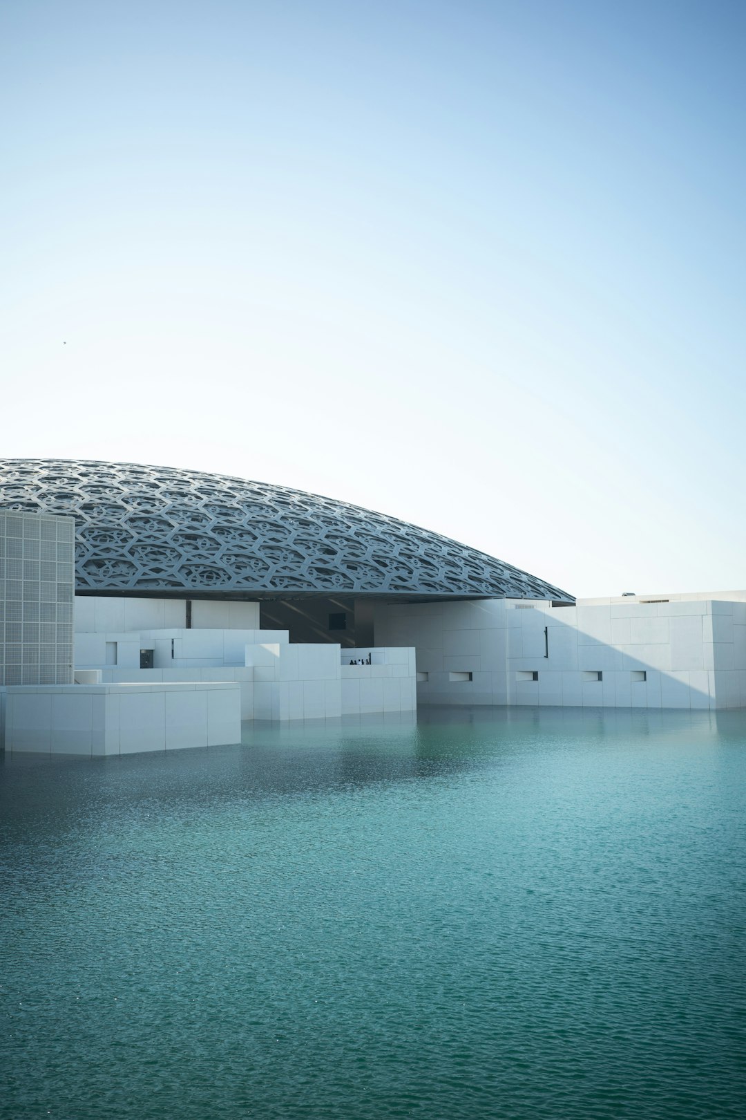 Modern building with a domed roof reflected in water