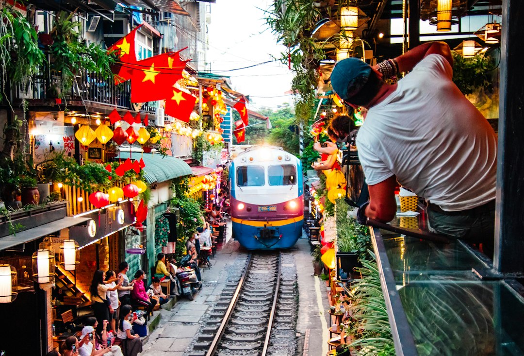 A train traveling down train tracks next to a crowd of people