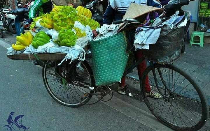 Bicycle vendor selling bananas in Hanoi's Old Quarter street.