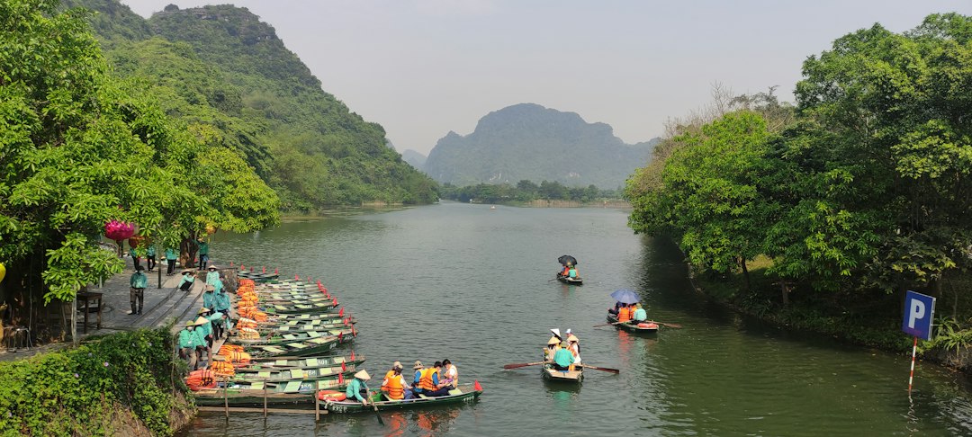 a river with boats and people on it with Yulong River in the background