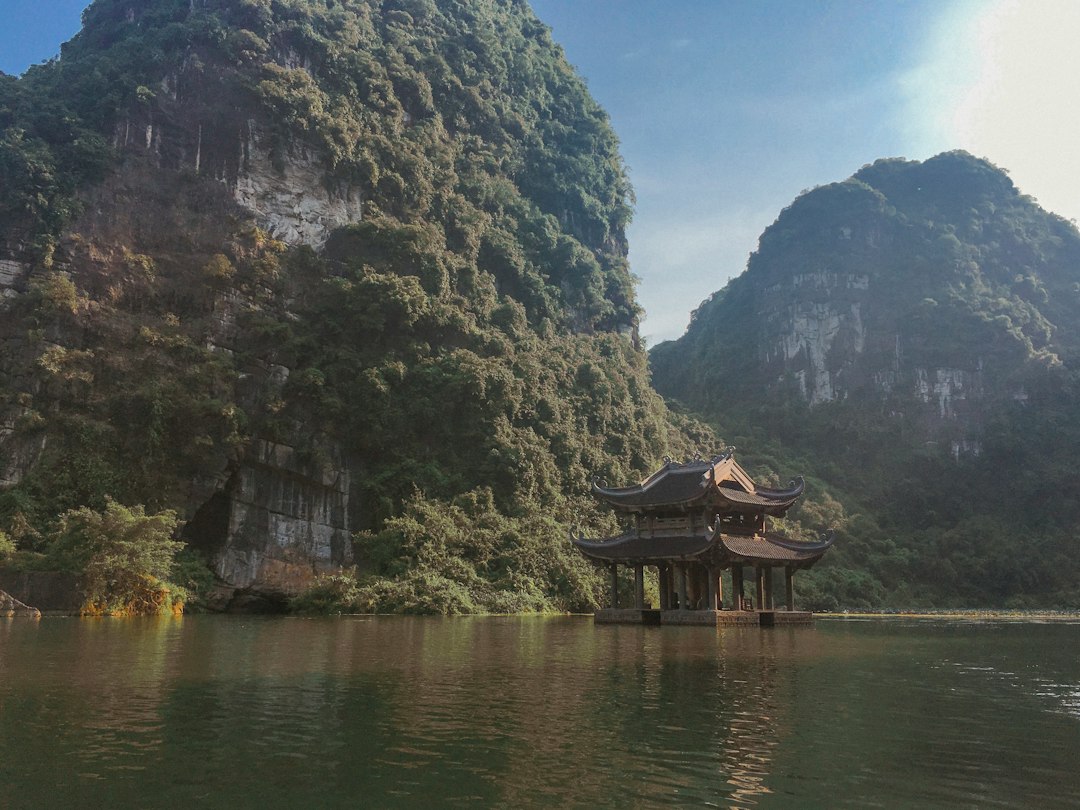 brown wooden house on rock formation beside body of water during daytime